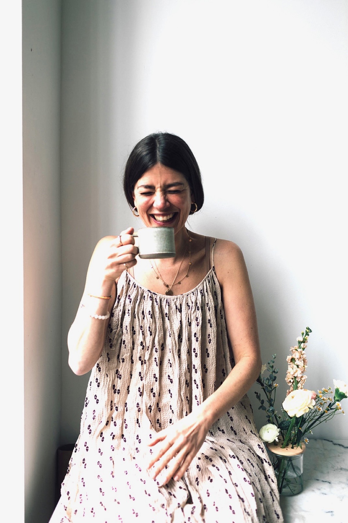Christiane lacht mit einer Tasse in der Hand